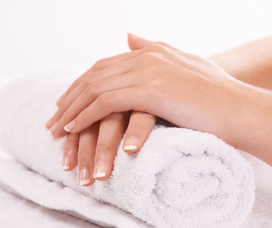Nail Care Do I need to let my nails breathe? Image of hands with french polish resting on a rolled white towel
